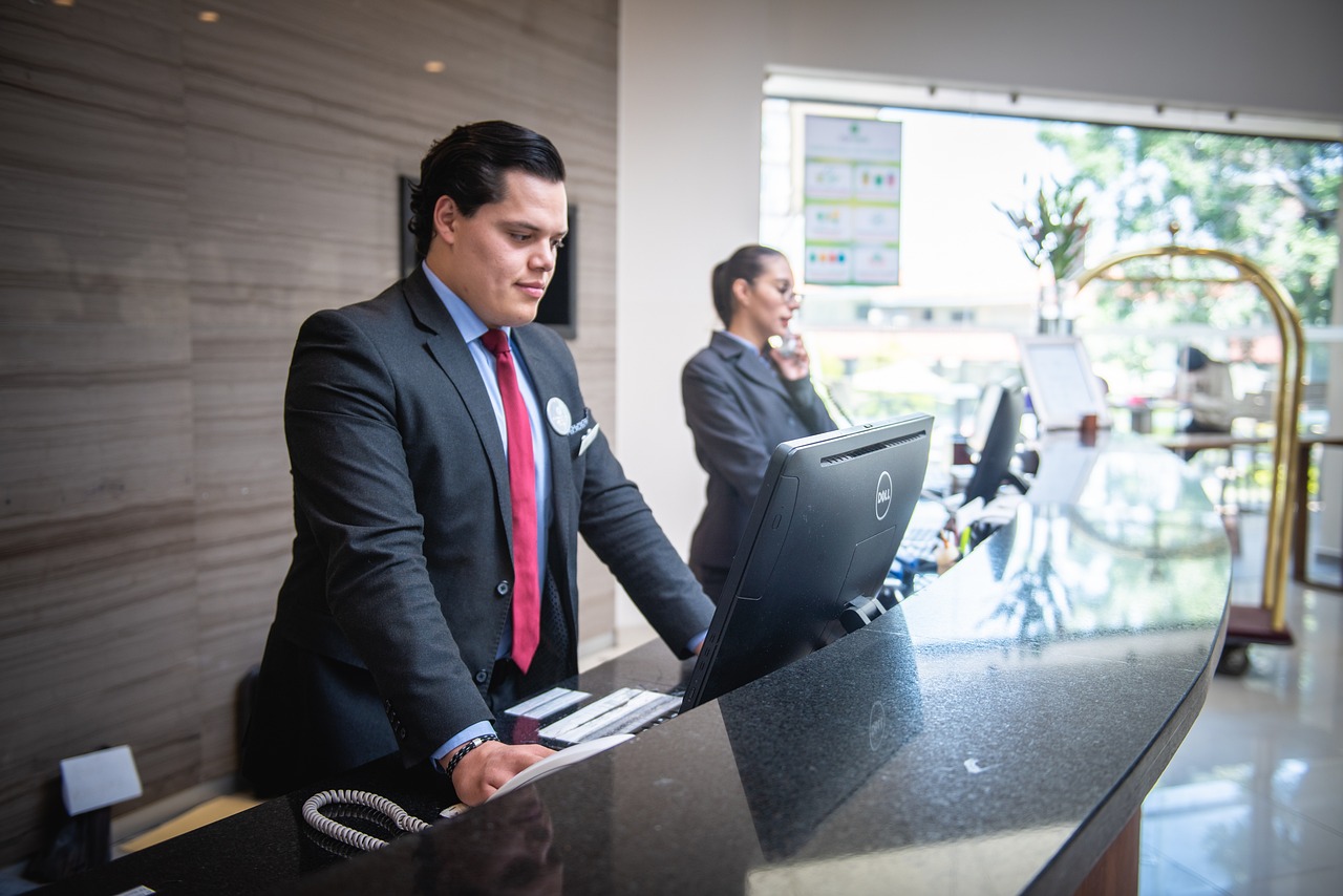 manager at hotel reception using a computer