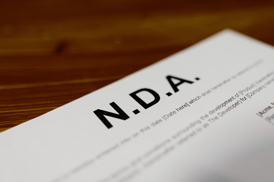 Close-up of a non-disclosure agreement document on a wooden table.