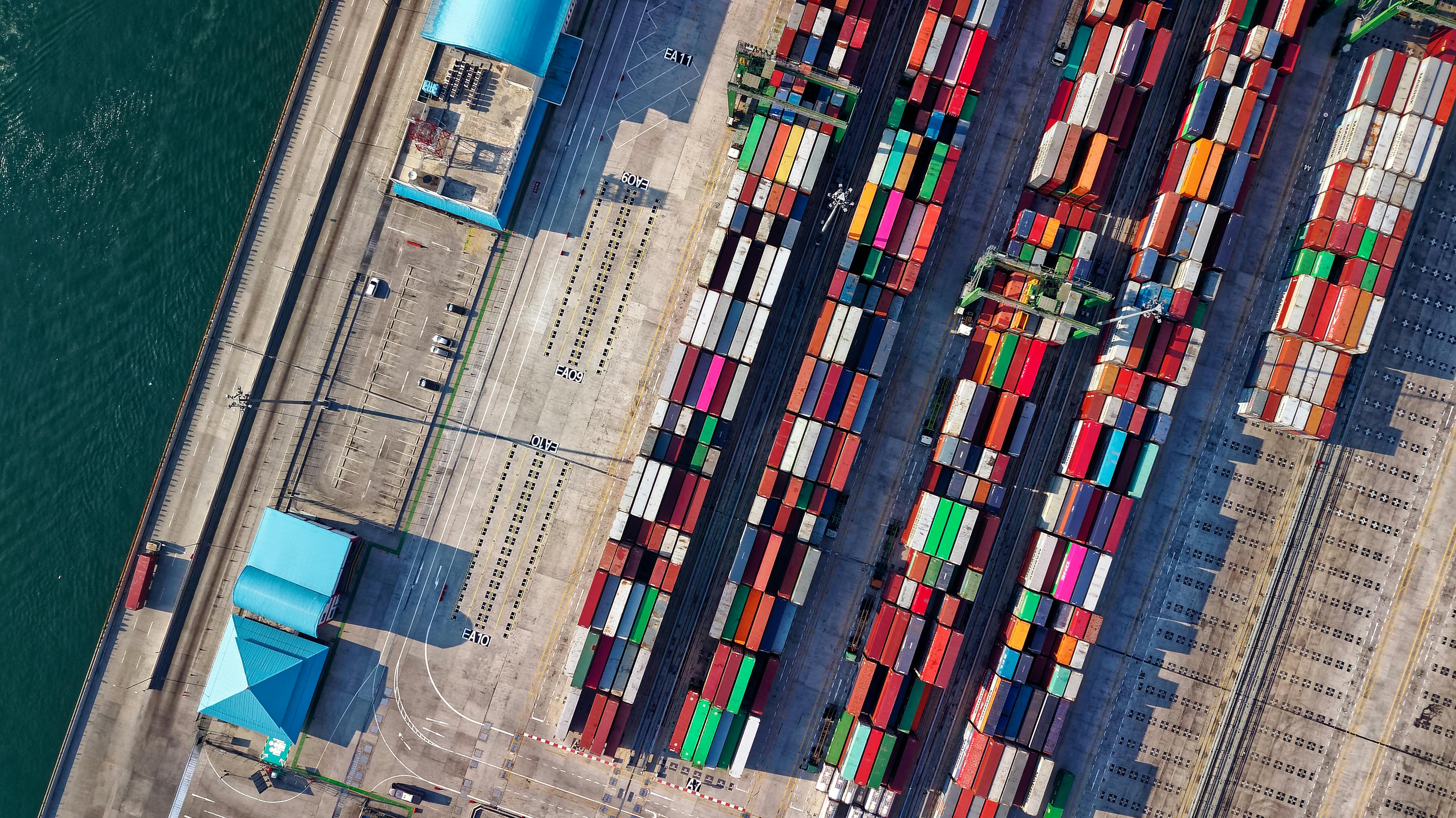 Aerial view photograph of colorful shipping containers stacked on dockside